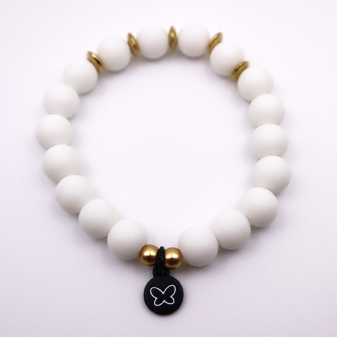 white beaded bracelet with gold accent beads and butterfly charm