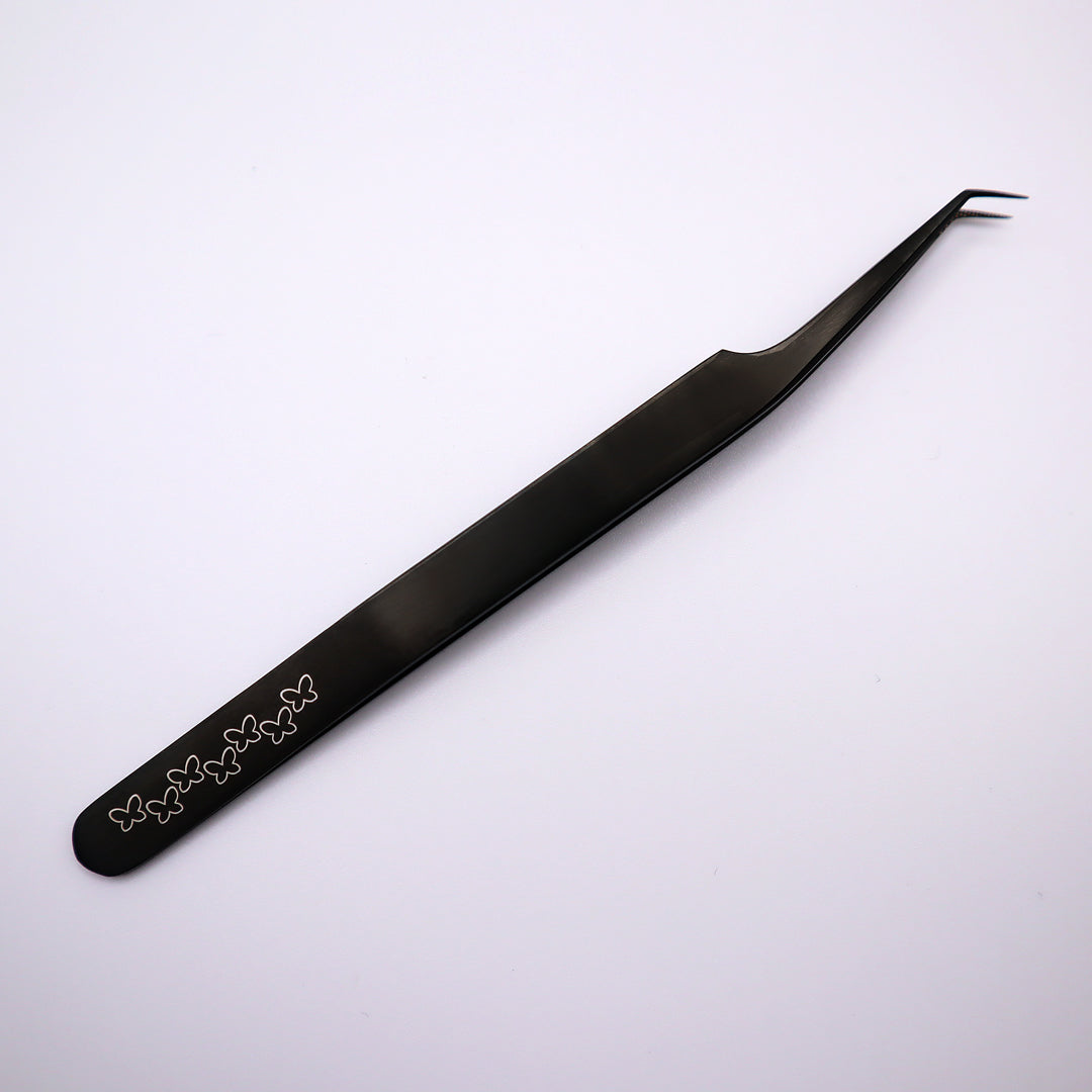 back of black fiber tip tweezer with slanted tip and butterfly stamped logo